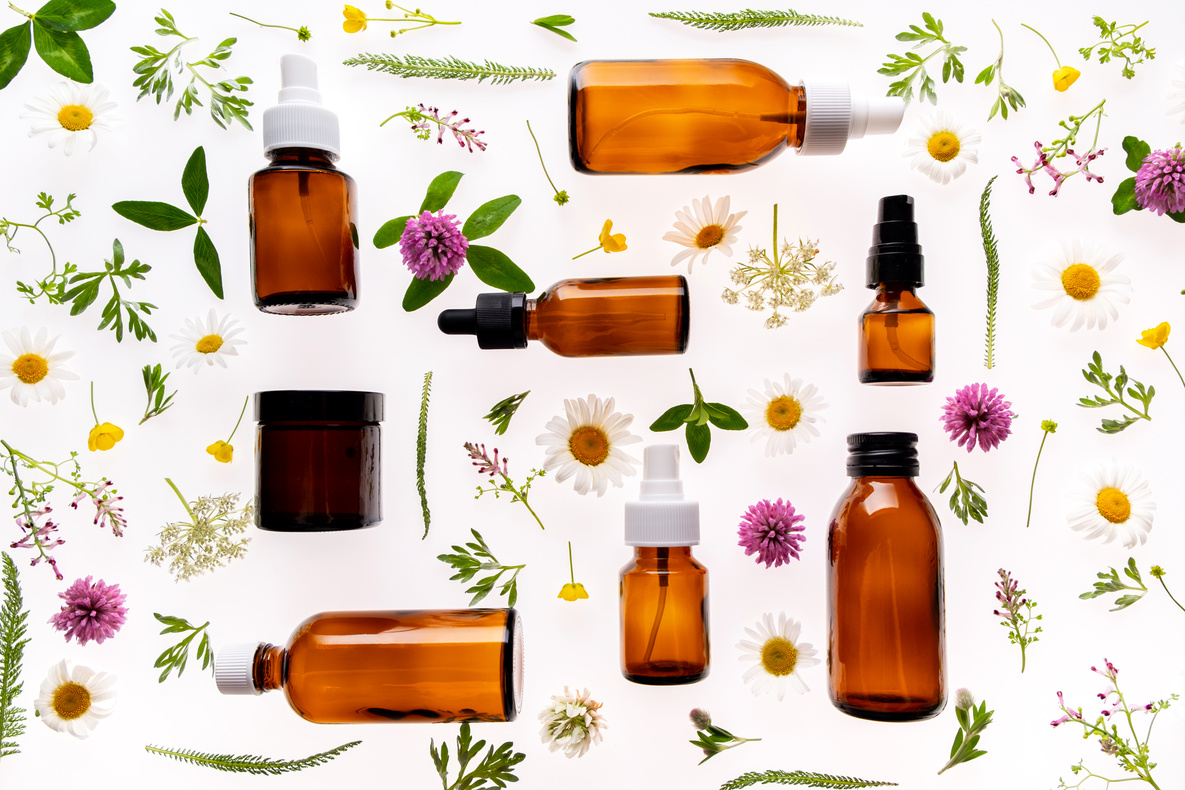 Flowers and Amber Glass Bottles on White Background